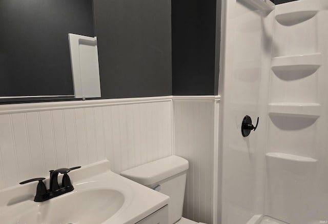 bathroom featuring vanity, toilet, and a shower