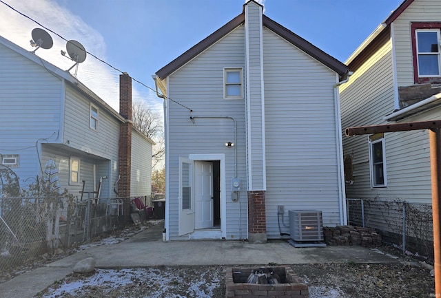 back of property featuring an outdoor fire pit and central AC