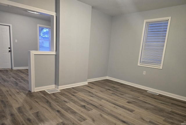 unfurnished room with dark hardwood / wood-style flooring