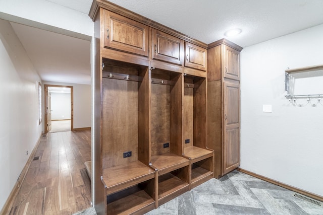 mudroom featuring a textured ceiling and light hardwood / wood-style floors