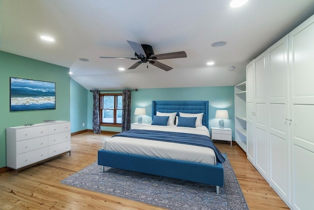 bedroom with a closet, light hardwood / wood-style floors, ceiling fan, and lofted ceiling