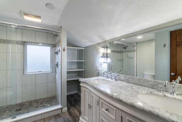 bathroom with vaulted ceiling, toilet, a textured ceiling, vanity, and hardwood / wood-style flooring