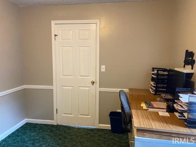 unfurnished office with dark colored carpet and a textured ceiling