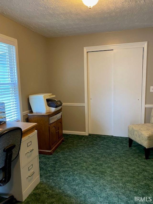 carpeted office featuring a textured ceiling