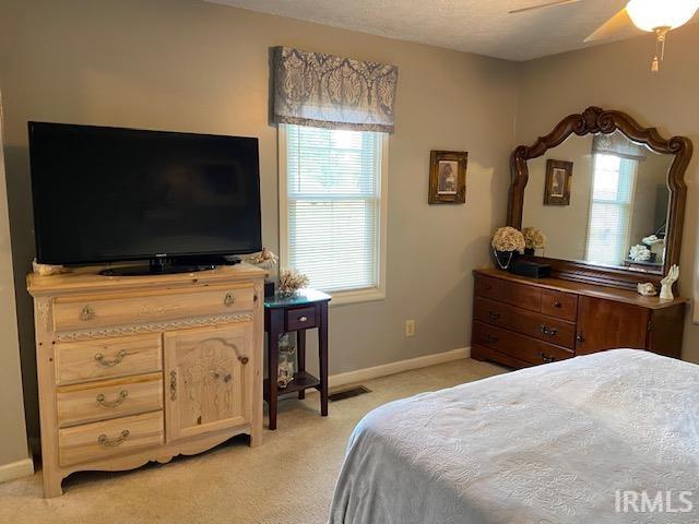 bedroom with light colored carpet and ceiling fan