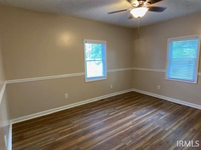 empty room featuring ceiling fan and dark hardwood / wood-style flooring