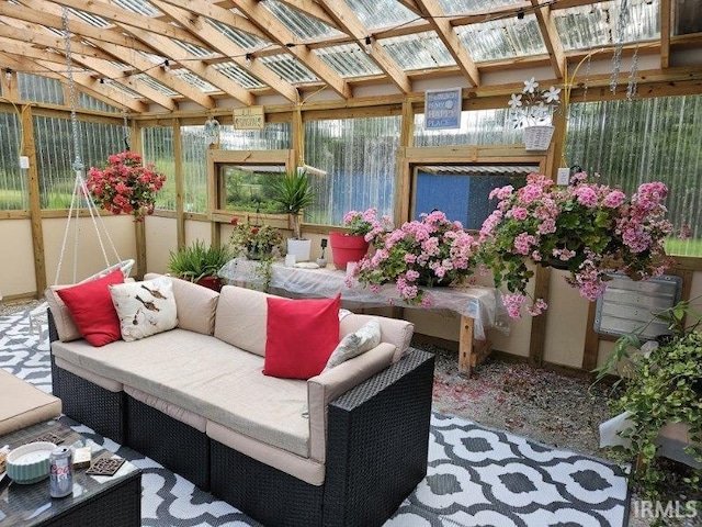 sunroom featuring vaulted ceiling and plenty of natural light