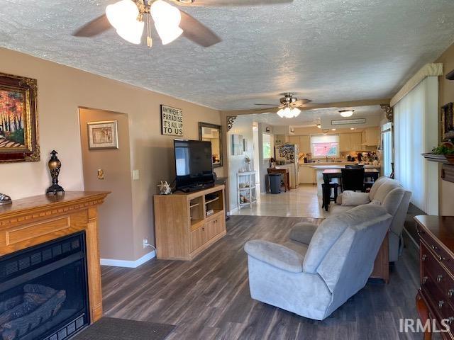 living room featuring a textured ceiling, dark hardwood / wood-style floors, and a wealth of natural light