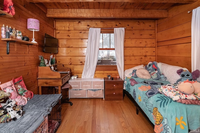 bedroom with wood walls, beam ceiling, wood ceiling, and light hardwood / wood-style flooring