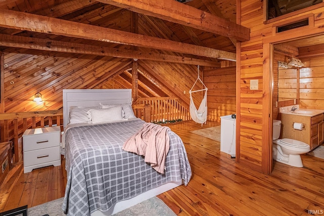 unfurnished bedroom with light wood-type flooring, wooden walls, sink, lofted ceiling with beams, and wooden ceiling