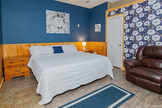 bedroom featuring wooden walls and tile patterned flooring