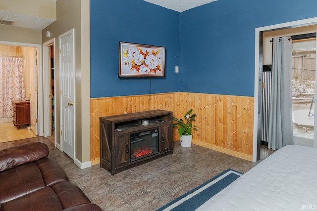 tiled bedroom featuring a textured ceiling and wood walls