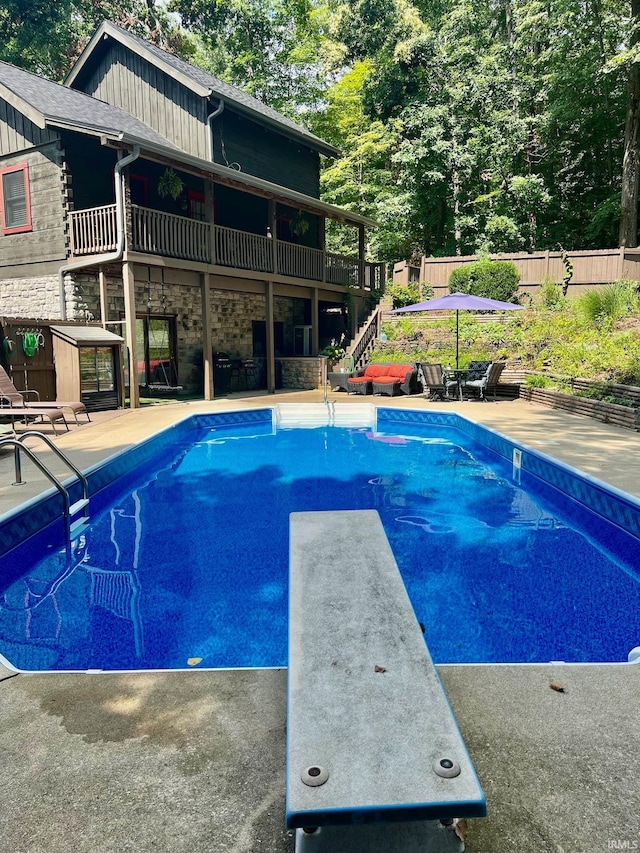 view of pool with a patio, a diving board, and a wooden deck