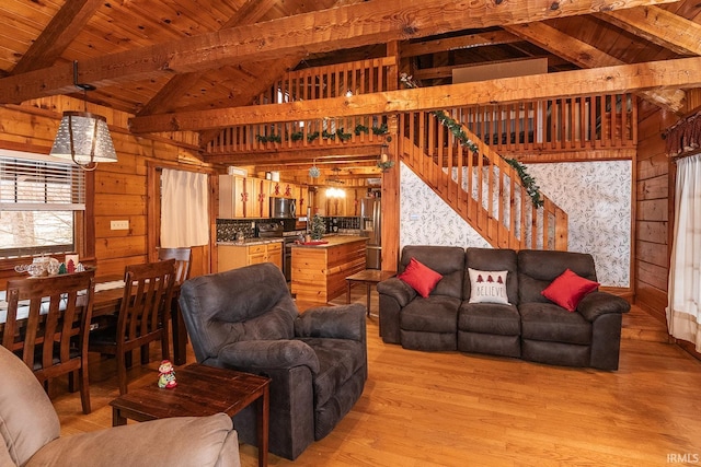 living room with wood walls, vaulted ceiling with beams, light hardwood / wood-style floors, and wood ceiling