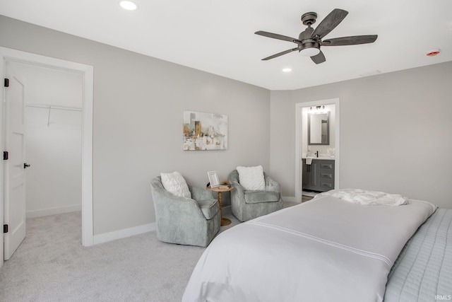 bedroom featuring light carpet, ensuite bathroom, ceiling fan, a spacious closet, and a closet