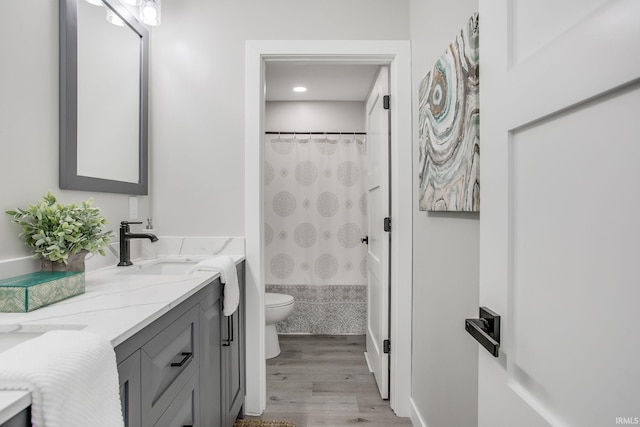 bathroom featuring toilet, vanity, and hardwood / wood-style flooring