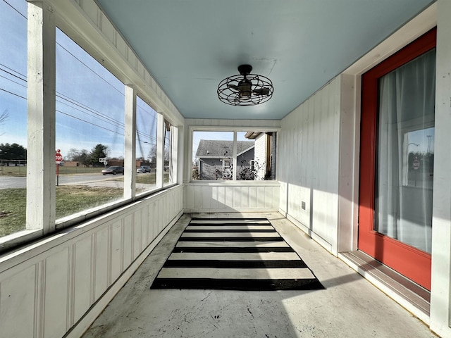 unfurnished sunroom featuring ceiling fan