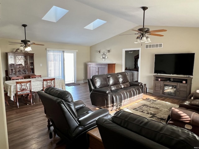 living room with vaulted ceiling with skylight, ceiling fan, and dark hardwood / wood-style floors