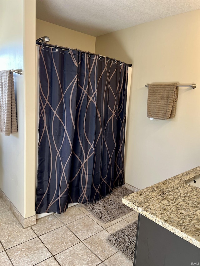 bathroom featuring tile patterned floors, vanity, and a textured ceiling