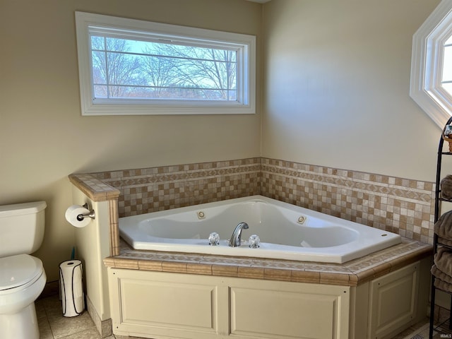 bathroom with tile patterned floors, a bathing tub, and toilet