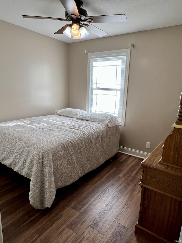 bedroom with ceiling fan and dark wood-type flooring