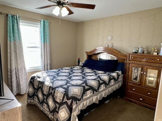 bedroom with dark colored carpet and ceiling fan