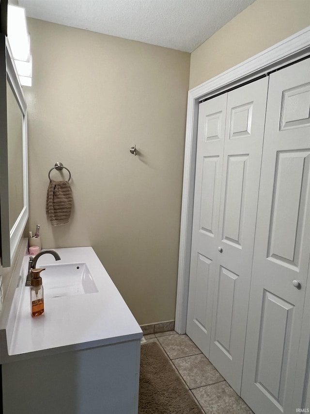 bathroom with a textured ceiling, vanity, and tile patterned floors