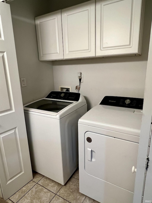 laundry area featuring cabinets, independent washer and dryer, and light tile patterned floors