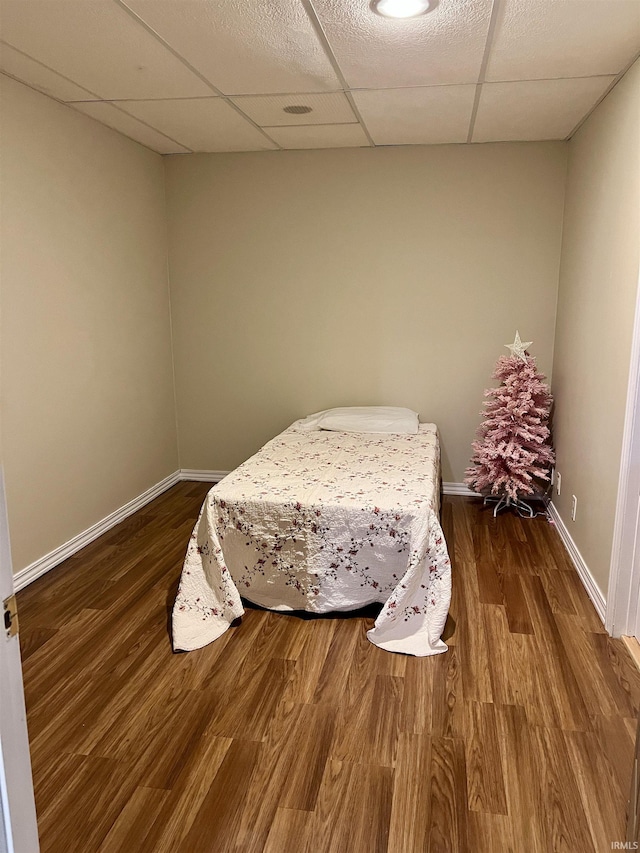 bedroom with dark hardwood / wood-style flooring and a drop ceiling