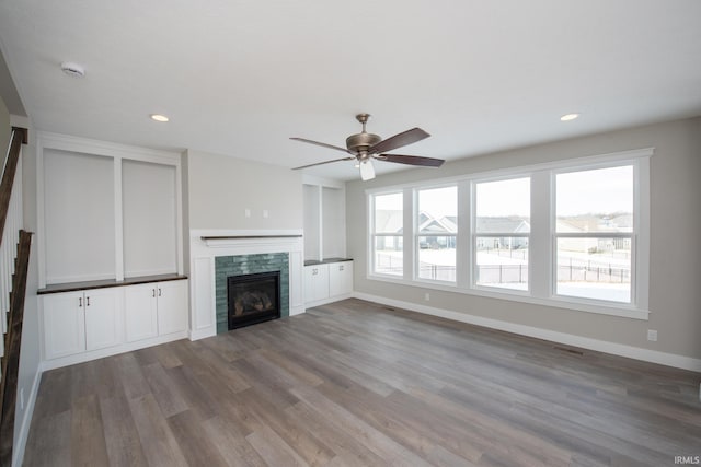 unfurnished living room featuring hardwood / wood-style flooring and ceiling fan