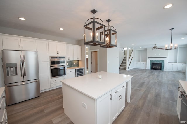 kitchen with white cabinets, appliances with stainless steel finishes, wine cooler, and a kitchen island