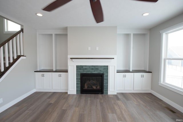 unfurnished living room with ceiling fan and wood-type flooring