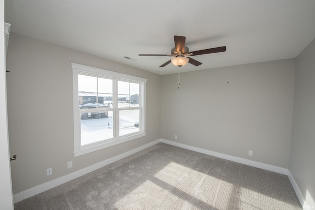 carpeted spare room with ceiling fan