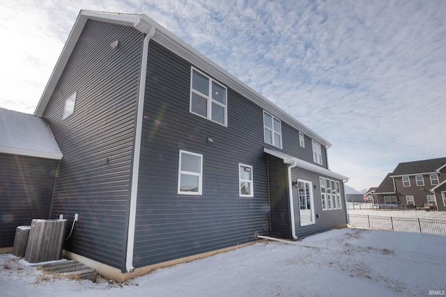 snow covered property with central air condition unit