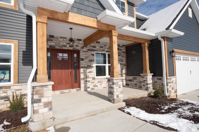 view of exterior entry with a porch and a garage