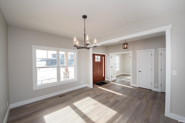 foyer with a notable chandelier and dark hardwood / wood-style flooring