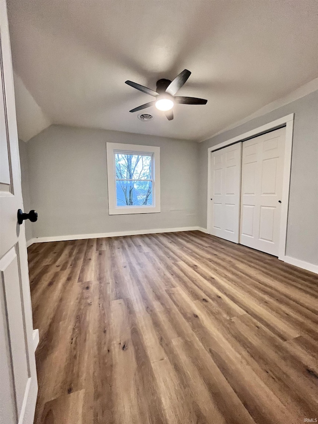 unfurnished bedroom with ceiling fan, wood-type flooring, a textured ceiling, vaulted ceiling, and a closet