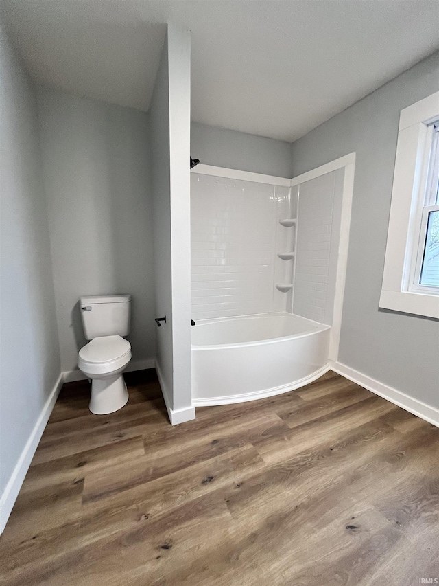 bathroom with shower / bathtub combination, toilet, and wood-type flooring