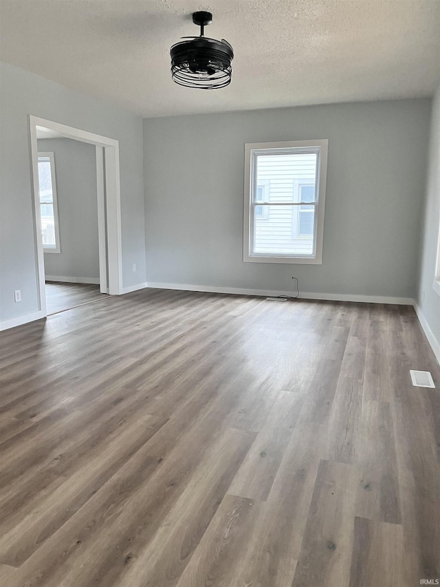 spare room featuring hardwood / wood-style floors and a textured ceiling