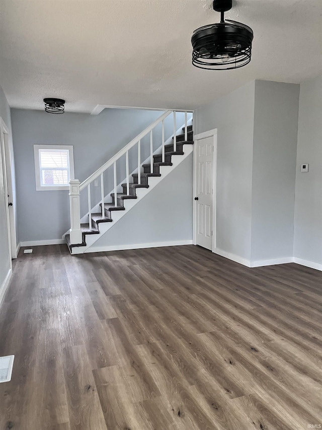 interior space with a textured ceiling and hardwood / wood-style flooring