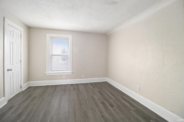 unfurnished room featuring a textured ceiling and dark hardwood / wood-style flooring