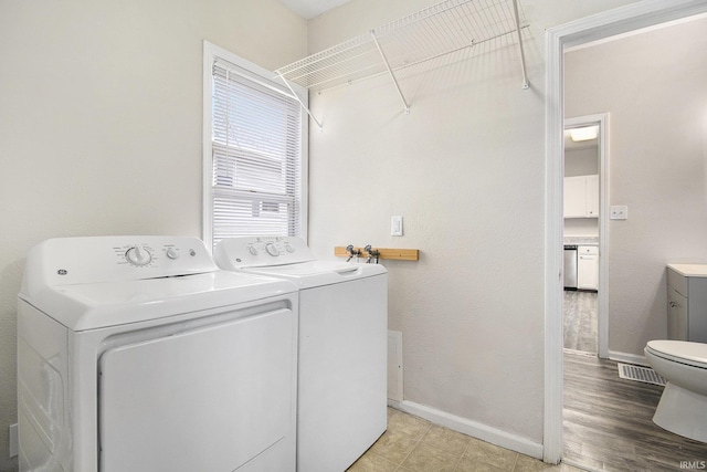 laundry room featuring light hardwood / wood-style floors and washing machine and dryer