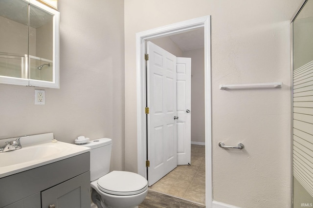 bathroom with vanity, toilet, and an enclosed shower