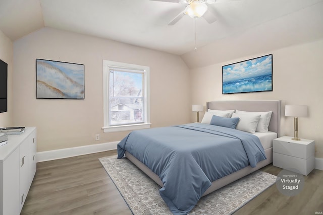 bedroom with ceiling fan, wood-type flooring, and vaulted ceiling