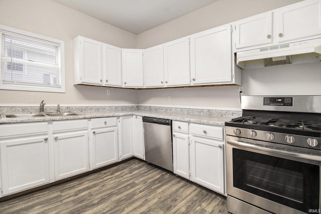 kitchen with sink, white cabinets, dark wood-type flooring, and appliances with stainless steel finishes