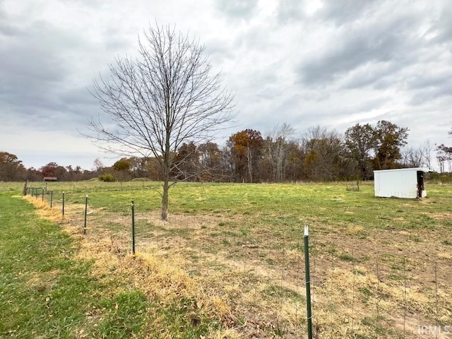 view of yard with a rural view and an outdoor structure