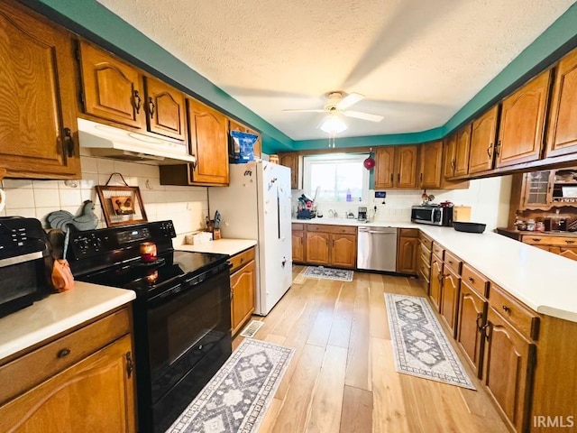 kitchen featuring ceiling fan, light hardwood / wood-style flooring, backsplash, a textured ceiling, and appliances with stainless steel finishes