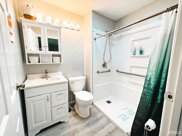 bathroom featuring a shower with curtain, toilet, vanity, and hardwood / wood-style flooring