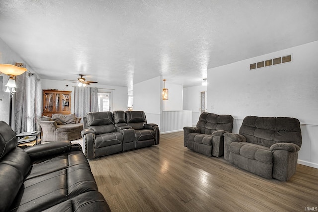 living room featuring wood-type flooring and a textured ceiling