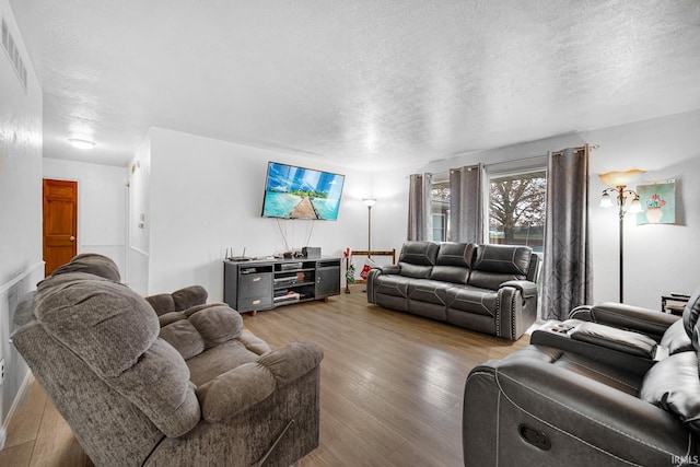 living room with hardwood / wood-style floors and a textured ceiling